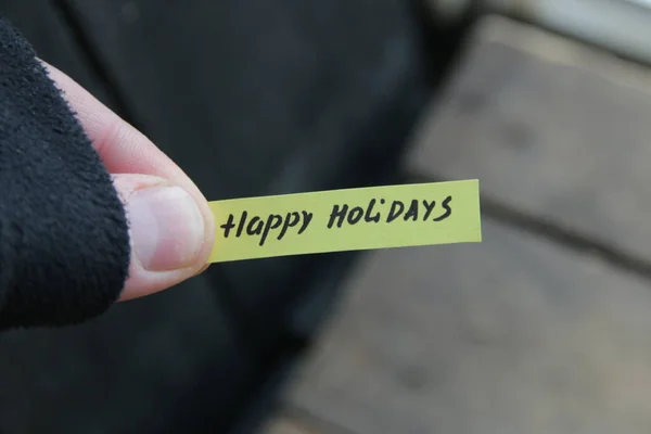 Happy Holidays, the inscription on the tag on the background of the old vintage table.
