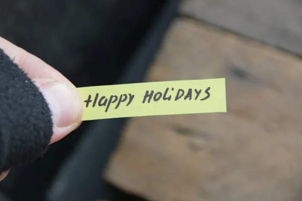 Happy Holidays, the inscription on the tag on the background of the old vintage table.