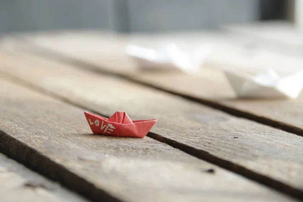 Love idea. Beautiful paper boats on a vintage wooden background.