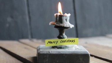 Mutlu noel etiketleri ve Candlestick 'i eski bir masanın üstünde. Noel kartı..