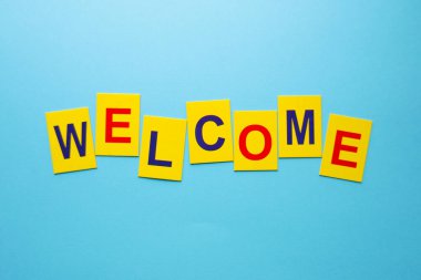 Hoş geldin. Tahta yüzeydeki sarı küplerin yazıtları..