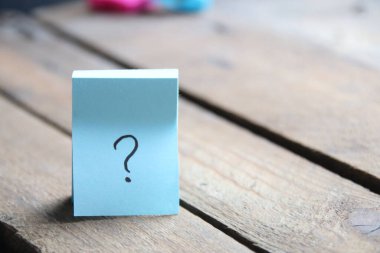 Large question mark on a wooden background..