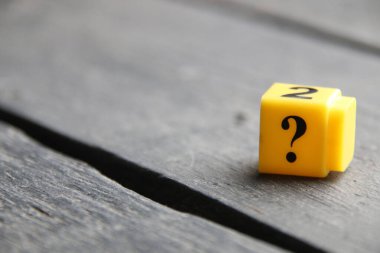 Large question mark on a wooden background..