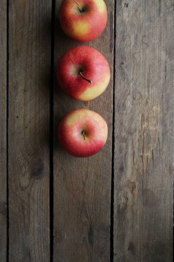 Eski ahşap bir arka planda olgun sulu elmalar.