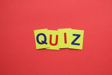 Quiz concept. The inscription on the yellow tags on a red background.