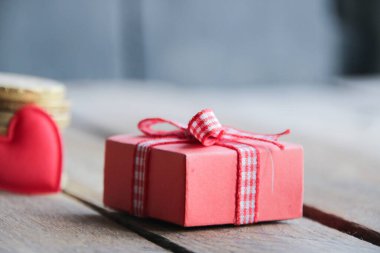 Güzel ahşap bir arka planda kurdelesi olan bir hediye..