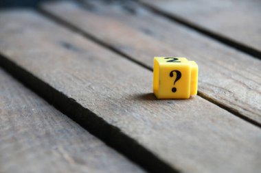 Large question mark on a wooden background..