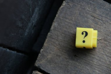 Large question mark on a wooden background..