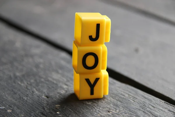 喜び創造的な概念 黄色のキューブの碑文 ストック写真