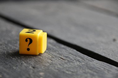 Large question mark on a wooden background..