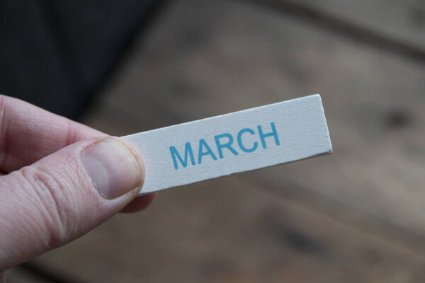 Творческая концепция Hello March. Рука держит табличку с надписью.