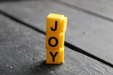 Joy creative concept, inscription on yellow cubes.