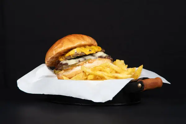 Fransız kızartması ve pembe soslu leziz çizburger: Bıçaklı Fast Food Menü, Siyah Arkaplan.