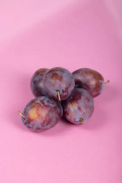 Canlı Pembe Fonda Sulu Mor Erikler: Taze Fruit Still Life, Sağlıklı Atıştırma, Organik Ürün ve Minimalist Gıda Fotoğrafçılığında Yaz Hasadı
