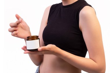 Amber Konteynırında Açık Krema Kavanozu Tutan Kadın Boş Etiket Cilt ve Marka ve Reklam İçin Güzellik Ürünleri Sunumu