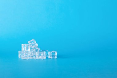 Canlı Mavi Arkaplan Minimalist Tasarım, Soğutma Kavramları ve Yaratıcı İçecek Görselleri Üzerine Kristal Berrak Buz Küpleri Yığıldı