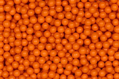 Canlı Portakal Şekeri Arkaplanı: Pasta Dekorasyonu ve Şekerleme Garnitürleri İçin Kullanılan Dekoratif Şeker İncilerinin Makro Fotoğrafı