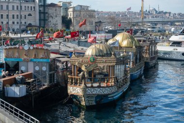 03.06.2025, İstanbul, İstanbul, İstanbul, İstanbul Limanı 'nda Altın Kubbeli Geleneksel Türk Tekneleri: Tarihi Camilerle Kentin Gökyüzüne Karşı Rıhtım Kıyısı boyunca Ulusal Bayraklı Turizm Gemileri