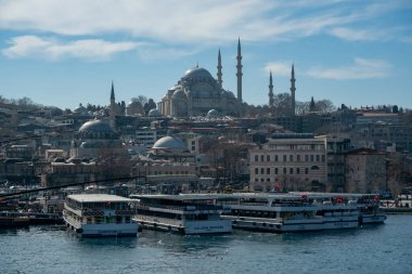 İstanbul 'un Panoramik Manzarası, Suleymaniye Cami Kubbeleri ve Minareler ile Gökyüzü Altında Boğaz Rıhtımında Turist Botlarıyla Yükseliyor