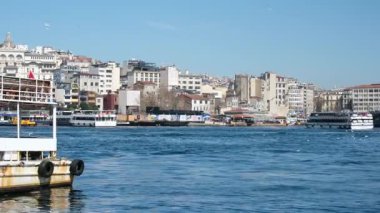İstanbul 'daki Galata Köprüsü' nden feribotlar, yolcu botları ve Martıların Güneşli Bir Deniz ve Şehir Sahnesinde Boğaz Üzerinde Uçuşu Manzarası