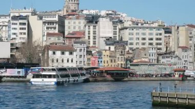 İstanbul 'daki Galata Köprüsü' nden feribotlar, yolcu botları ve Martıların Güneşli Bir Deniz ve Şehir Sahnesinde Boğaz Üzerinde Uçuşu Manzarası