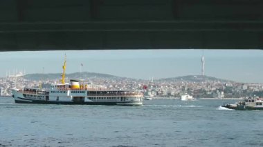 İstanbul 'daki Galata Köprüsü' nden feribotlar, yolcu botları ve Martıların Güneşli Bir Deniz ve Şehir Sahnesinde Boğaz Üzerinde Uçuşu Manzarası