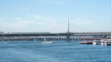 İstanbul 'daki Galata Köprüsü' nden feribotlar, yolcu botları ve Martıların Güneşli Bir Deniz ve Şehir Sahnesinde Boğaz Üzerinde Uçuşu Manzarası