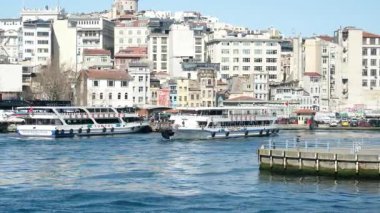 İstanbul 'daki Galata Köprüsü' nden feribotlar, yolcu botları ve Martıların Güneşli Bir Deniz ve Şehir Sahnesinde Boğaz Üzerinde Uçuşu Manzarası