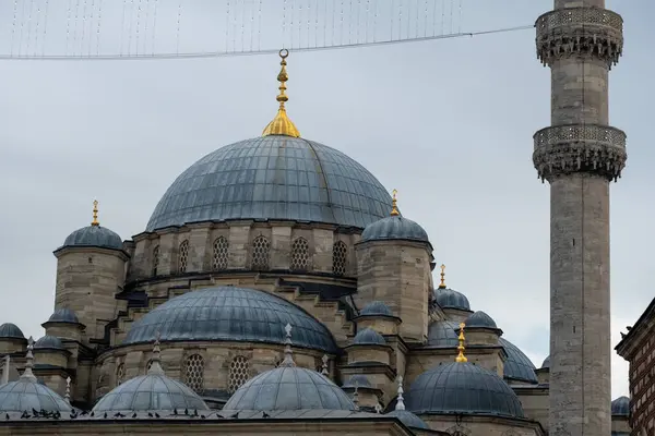 Majestic Ottoman Architecture of the New Mosque in Istanbul: Stunning Domes, Minaret, and Golden Accents Showcasing Cultural Heritage