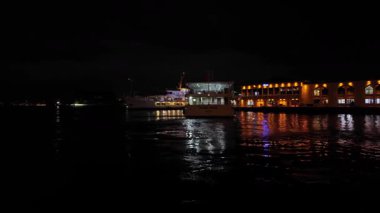 04.03.2025, İstanbul, Türkiye. Gece yolcu gemisi rıhtımdan ayrılıyor. İskelede başka tekneler de var.. 