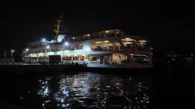 04.03.2025, İstanbul, Türkiye. Feribot gece rıhtımdan ayrılıyor. Feribot ışıklarla parlıyor.. 