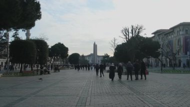 04.03.2025, İstanbul, Türkiye. Türkiye 'nin başkenti İstanbul' da Antik Mısır Obelisk ve Mavi Cami Minaresi ile Tarihi Sultanahmet Meydanı 'nda Yürüyen Turist kalabalığı, Güneşli Bir Gün Popüler Seyahat ve Kültürel Tarihi Yer İmlerinde