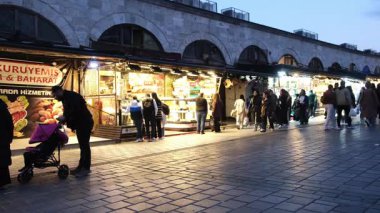 04.03.2025, İstanbul, Türkiye. İnsanlar akşamları tarihi Baharat Pazarı 'nın önünde alışveriş yapıyorlar..