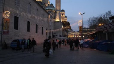 03.04.205, İstanbul, Türkiye. Eminn Meydanı 'ndaki Akşam Ortamı: İstanbul' daki Aydınlanmış Mavi Cami 'nin Önünde Yürüyen İnsanlar, Mimarlık ve Canlı Kent Yaşamını Gösteriyor