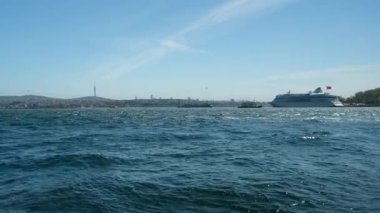 İstanbul 'daki Karaky Sahili' nden Windy Bosphorus Manzarası Dalgalı Mavi Deniz, Seyir Gemisi, Şehir Skyline, TV Kulesi ve Açık Hava Altında Açık Hava Deniz Burnu Altında Açık Hava