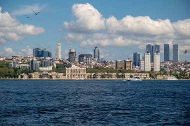 Başlık: Tarihi Dolmabahe Sarayı ve Çağdaş Gökdelenlerle İstanbul Rıhtım Panoraması - Açık Mavi Gökyüzü ile Güneşli Gün 'de Türk Şehri Gökyüzü Karşısı Gökyüzü Manzarası