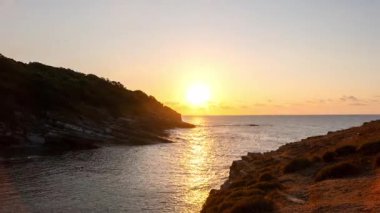 Sardala Körfezi Kocaeli 'nde dalgaların çarptığı kayalık sahil şeridinde gün batımı - dramatik bir gökyüzü ve sakin deniz ışığı yansıtan deniz manzarası