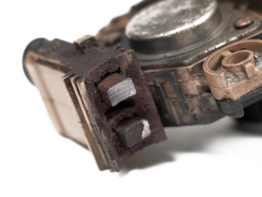 Heavily worn graphite brushes of an automobile alternator, isolated on a white background, close-up, selective focus.