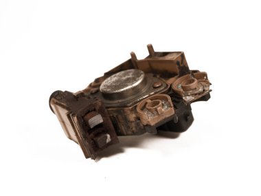 Heavily worn graphite brushes of an automobile alternator, isolated on a white background, close-up, selective focus.