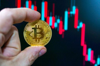 Bitcoin gösteren kripto para tüccarı şamdan grafiğindeki düşen fiyatlara bakarken