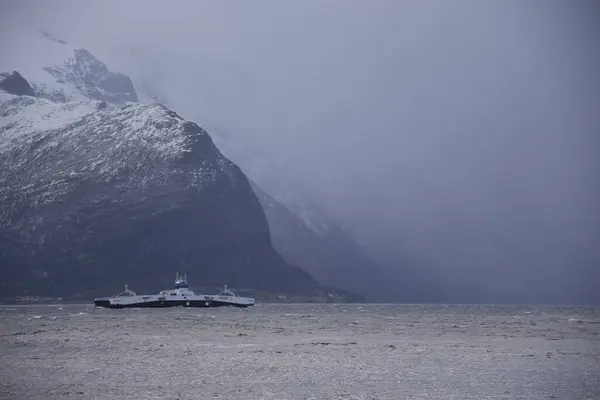 Storfjorden, Norveç - 2 Şubat 2024: Ingunn fırtınası sırasında dağlar arasında bir feribot hareket eder