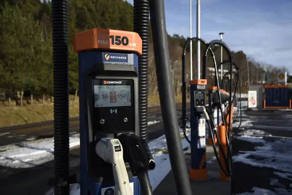 Bir elektrikli araç (EV) şarj istasyonu, açık alanda birden fazla şarj aleti var. Kış manzarası, yerde kar, arka planda bir gökyüzü. Aalesund, Norveç - 17 Şubat 2024