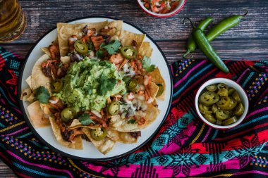 Mexican Nachos with cheese or tortilla chips with meat, avocado and beer, tex mex food in Mexico America