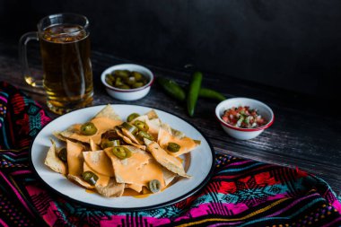 Mexican nachos with cheese or tortilla chips with american cheese and beer traditional food in Mexico Latin America
