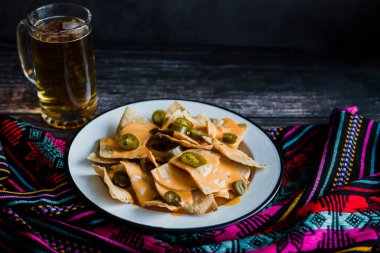 Mexican nachos with cheese or tortilla chips with american cheese and beer traditional food in Mexico Latin America