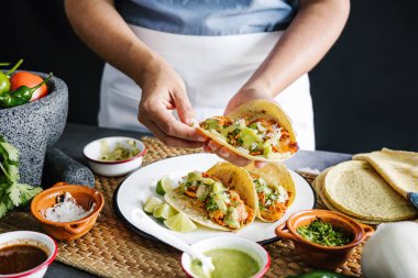 Meksikalı kadın Meksika Latin Amerika 'da taco hazırlıyor ve Meksika yemeği yiyor.