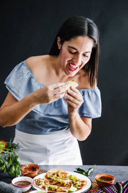 Meksikalı kadın Meksika Latin Amerika 'da taco hazırlıyor ve Meksika yemeği yiyor.