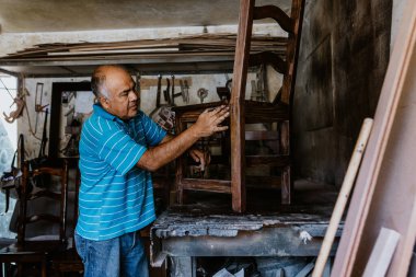 Latin Amerika 'daki mobilya atölyesinde çalışan İspanyol kıdemli marangoz.