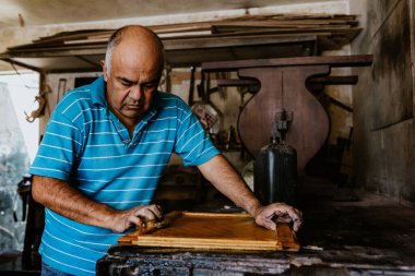 Latin Amerika 'daki mobilya atölyesinde çalışan İspanyol kıdemli marangoz.