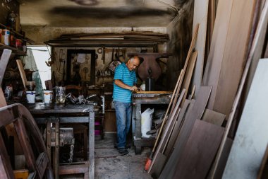 Latin Amerika 'daki mobilya atölyesinde çalışan İspanyol kıdemli marangoz.